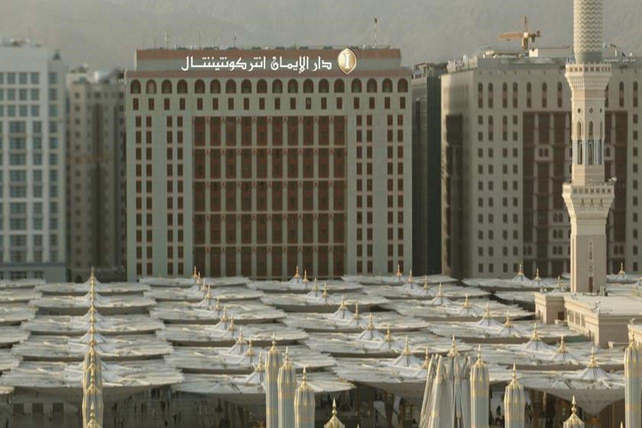 Intercontinental Dar Al Iman Madinah By Ihg Ξενοδοχείο Μεδίνα Εξωτερικό φωτογραφία The photo shows a view of a large building with a modern architectural design, which appears to be a hotel or a commercial establishment. In front of the building, there are several large white canopies that provide shade, likely in a public space or