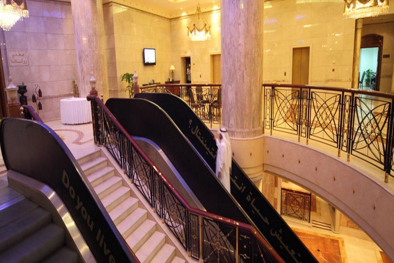 Intercontinental Dar Al Iman Madinah By Ihg Ξενοδοχείο Μεδίνα Εσωτερικό φωτογραφία The photo depicts an elegant interior space, likely within a hotel or a large building. There is a grand staircase visible, which features a combination of stairs and escalators. The design includes decorative railings and marble pillars, contributin